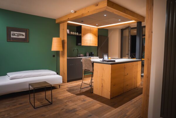 Espacio abierto con isla central iluminada por downlights